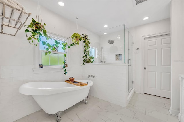 624 Richmond St, Orlando, FL 32806 - full bathroom with tile walls, a stall shower, a soaking tub, marble look tile flooring, and plenty of natural light