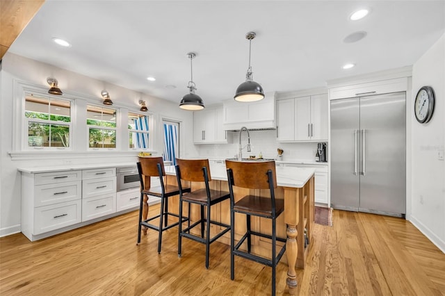 624 Richmond St, Orlando, FL 32806 - kitchen with built in refrigerator, white cabinetry, a kitchen breakfast bar, and recessed lighting