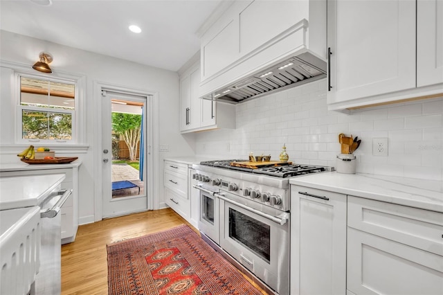 624 Richmond St, Orlando, FL 32806 - kitchen with double oven range, backsplash, white cabinetry, light wood finished floors, and recessed lighting