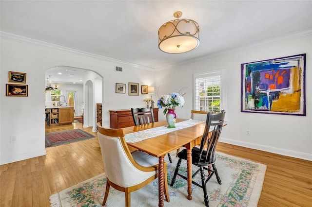 624 Richmond St, Orlando, FL 32806 - dining area with arched walkways, light wood-type flooring, and ornamental molding