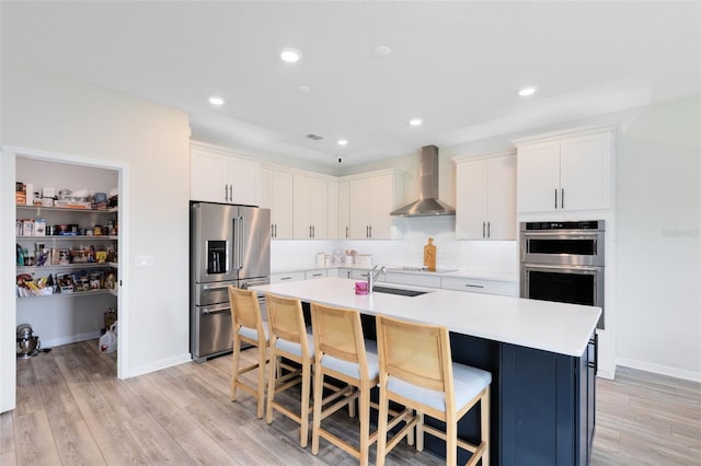 5677 Cedar Chase Dr, Saint Cloud, FL 34771 - kitchen featuring appliances with stainless steel finishes, wall chimney range hood, a kitchen breakfast bar, backsplash, and a center island with sink