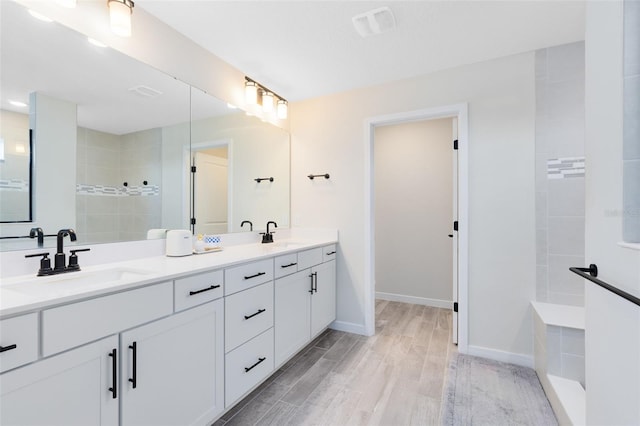 5677 Cedar Chase Dr, Saint Cloud, FL 34771 - bathroom with double vanity, wood finished floors, and a walk in shower