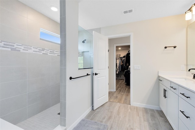 5677 Cedar Chase Dr, Saint Cloud, FL 34771 - full bathroom featuring vanity, walk in shower, a walk in closet, wood finished floors, and recessed lighting