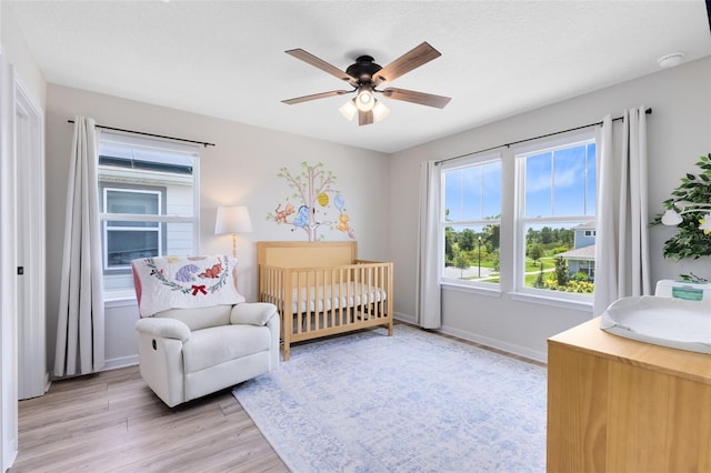 5677 Cedar Chase Dr, Saint Cloud, FL 34771 - bedroom with light wood-type flooring, a nursery area, and ceiling fan