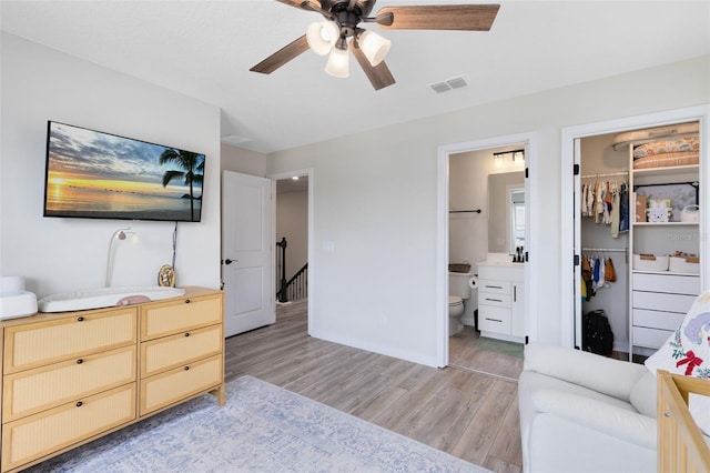 5677 Cedar Chase Dr, Saint Cloud, FL 34771 - bedroom featuring light wood-type flooring, connected bathroom, ceiling fan, a closet, and a spacious closet