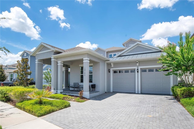 14189 Larkspur Lake Dr, Winter Garden, FL 34787 - view of front of house featuring a porch, a garage, decorative driveway, stucco siding, and a standing seam roof