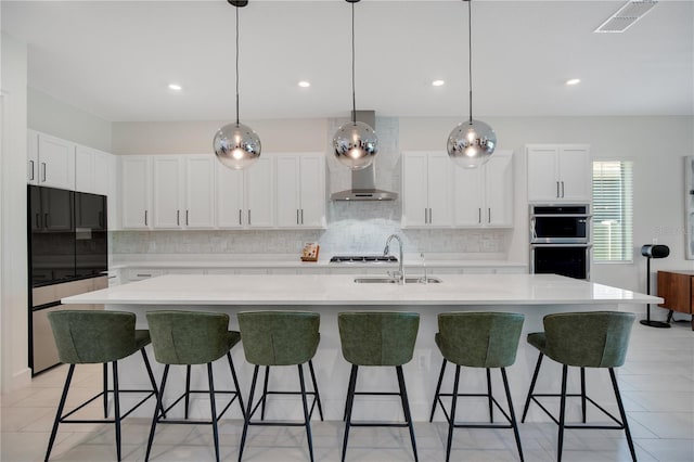 14189 Larkspur Lake Dr, Winter Garden, FL 34787 - kitchen with wall chimney exhaust hood, backsplash, a breakfast bar, white cabinets, and double oven