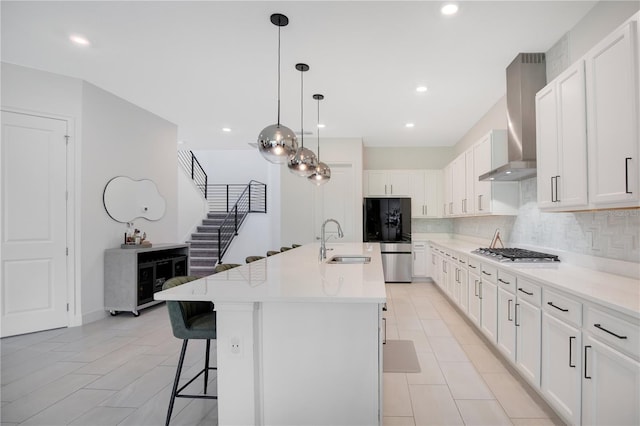 14189 Larkspur Lake Dr, Winter Garden, FL 34787 - kitchen with appliances with stainless steel finishes, wall chimney exhaust hood, decorative backsplash, an island with sink, and a kitchen bar