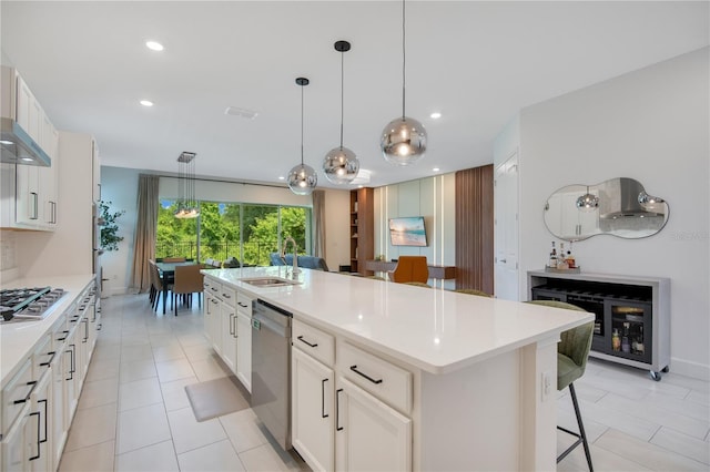 14189 Larkspur Lake Dr, Winter Garden, FL 34787 - kitchen featuring appliances with stainless steel finishes, a breakfast bar area, light countertops, an island with sink, and decorative light fixtures