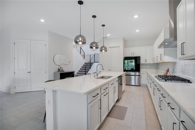 14189 Larkspur Lake Dr, Winter Garden, FL 34787 - kitchen featuring stainless steel appliances, wall chimney exhaust hood, tasteful backsplash, white cabinets, and pendant lighting