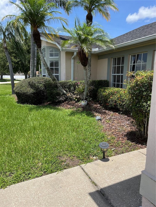 2421 Queenswood Cir, Kissimmee, FL 34743 - view of side of home featuring a lawn and stucco siding