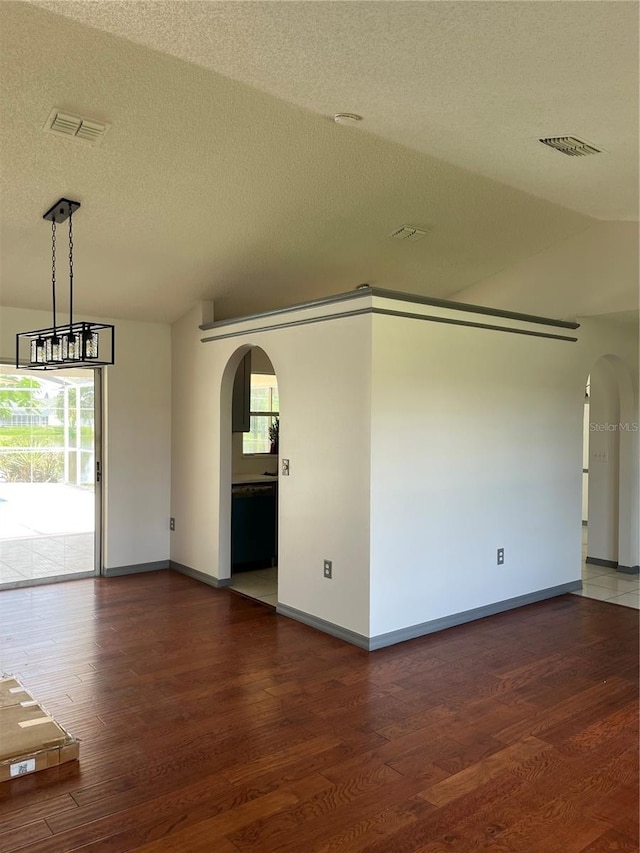 2421 Queenswood Cir, Kissimmee, FL 34743 - spare room with arched walkways, wood finished floors, and a textured ceiling