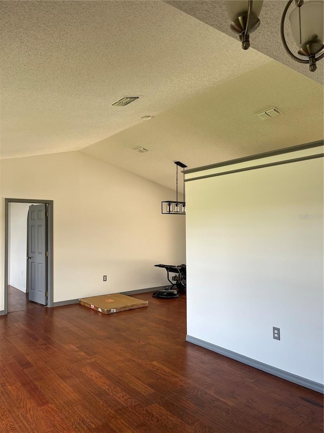 2421 Queenswood Cir, Kissimmee, FL 34743 - spare room with vaulted ceiling, dark wood-type flooring, and a textured ceiling