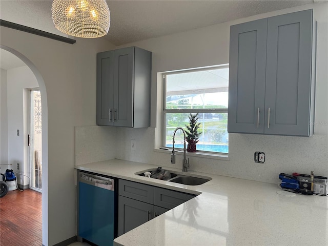 2421 Queenswood Cir, Kissimmee, FL 34743 - kitchen featuring dishwashing machine, gray cabinets, arched walkways, and decorative backsplash
