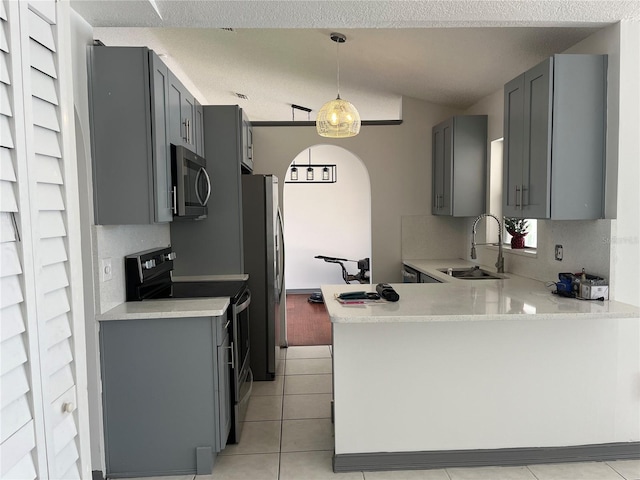 2421 Queenswood Cir, Kissimmee, FL 34743 - kitchen featuring appliances with stainless steel finishes, gray cabinetry, arched walkways, light countertops, and lofted ceiling
