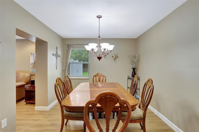 dining area with a chandelier and light wood-type flooring