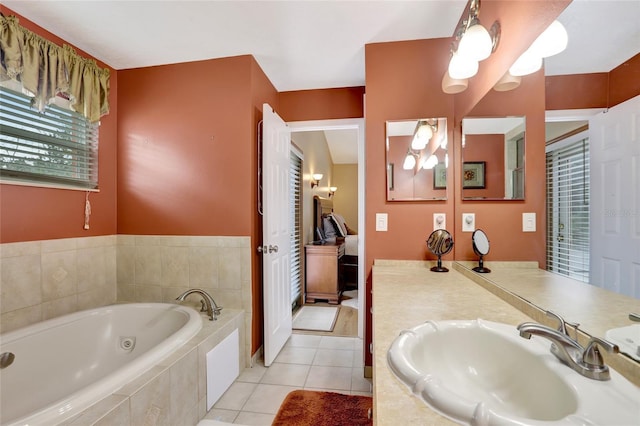 full bath with a jetted tub, vanity, tile patterned floors, and ensuite bath