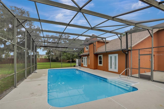 outdoor pool featuring french doors, a patio, a lawn, and glass enclosure