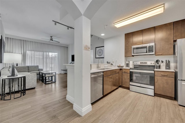 14501 Grove Resort Ave Unit 3239, Winter Garden, FL 34787 - kitchen with appliances with stainless steel finishes, open floor plan, light wood-style floors, and light countertops