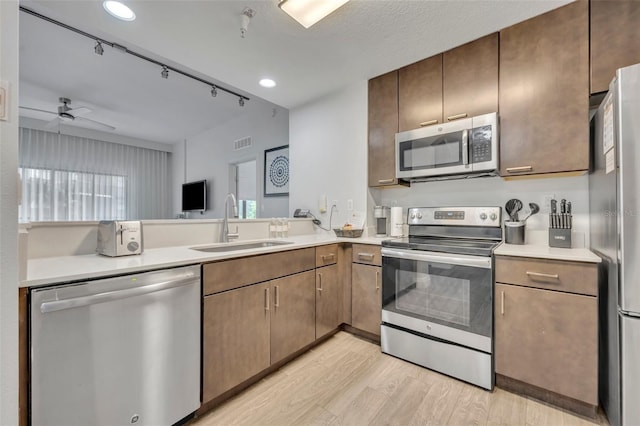 14501 Grove Resort Ave Unit 3239, Winter Garden, FL 34787 - kitchen featuring stainless steel appliances, light wood-style flooring, light countertops, a ceiling fan, and a peninsula
