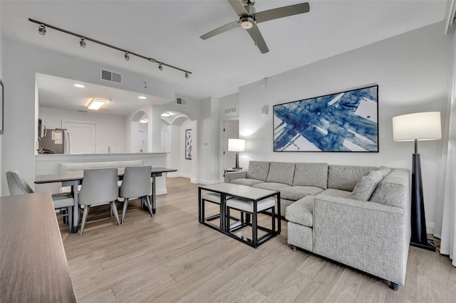 14501 Grove Resort Ave Unit 3239, Winter Garden, FL 34787 - living room with arched walkways, a ceiling fan, rail lighting, and light wood finished floors