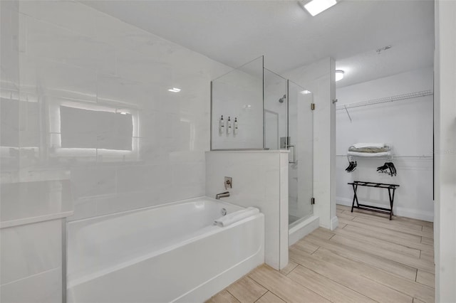 14501 Grove Resort Ave Unit 3239, Winter Garden, FL 34787 - bathroom with a stall shower, a garden tub, wood finished floors, and a spacious closet