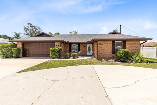 1736 Saxon Blvd, Deltona, FL 32725 - view of front facade with brick siding, a garage, concrete driveway, and a shingled roof