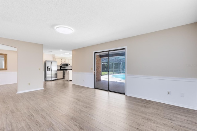 1736 Saxon Blvd, Deltona, FL 32725 - unfurnished living room featuring light wood-style floors and a textured ceiling