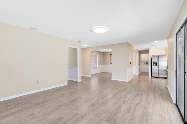 1736 Saxon Blvd, Deltona, FL 32725 - unfurnished living room with arched walkways and light wood-style flooring