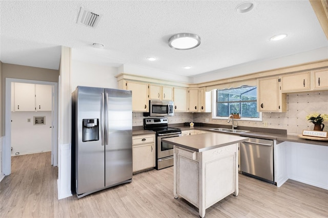 1736 Saxon Blvd, Deltona, FL 32725 - kitchen featuring appliances with stainless steel finishes, light wood-style flooring, tasteful backsplash, a kitchen island, and dark countertops