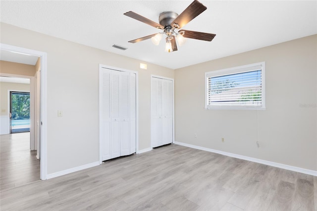 1736 Saxon Blvd, Deltona, FL 32725 - unfurnished bedroom with two closets, light wood-style floors, and ceiling fan