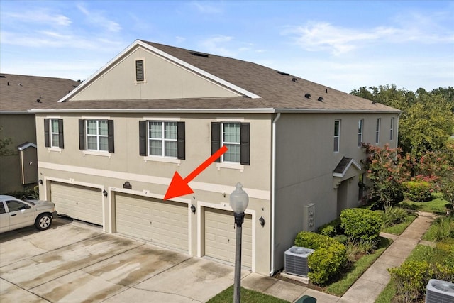 3537 Seneca Club Loop Unit B, Orlando, FL 32808 - view of property with central AC unit, an attached garage, driveway, and stucco siding