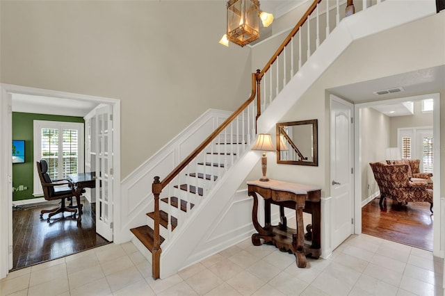 991 Hawthorne Cove Ct, Ocoee, FL 34761 - stairway with a towering ceiling, wood finished floors, and french doors