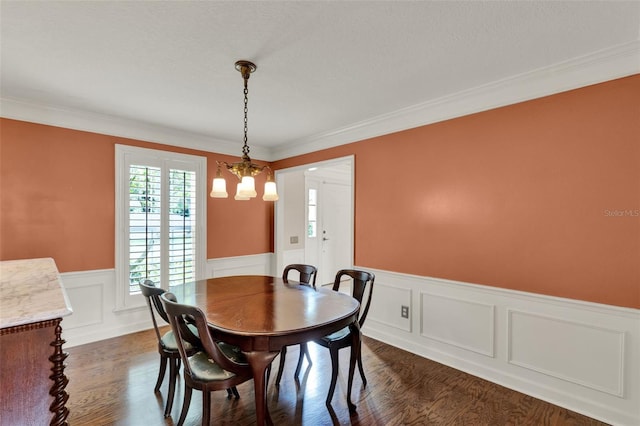 991 Hawthorne Cove Ct, Ocoee, FL 34761 - dining space featuring a wainscoted wall, a chandelier, dark wood-style floors, ornamental molding, and a decorative wall