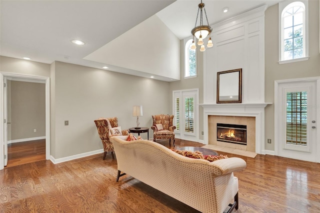 991 Hawthorne Cove Ct, Ocoee, FL 34761 - living area with wood finished floors, plenty of natural light, a tiled fireplace, a high ceiling, and recessed lighting