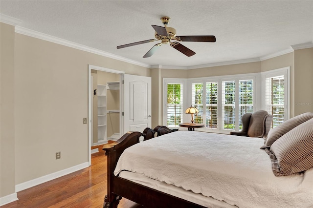 991 Hawthorne Cove Ct, Ocoee, FL 34761 - bedroom with wood finished floors, ornamental molding, a ceiling fan, and a walk in closet