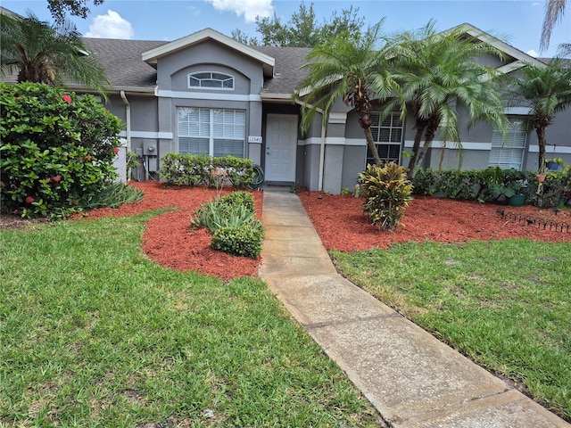 13546 Summerton Dr, Orlando, FL 32824 - ranch-style home with stucco siding, a front yard, and a shingled roof