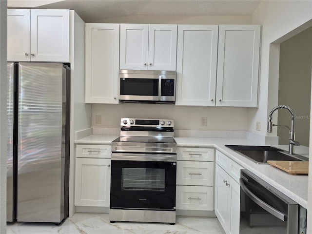 13546 Summerton Dr, Orlando, FL 32824 - kitchen featuring stainless steel appliances, light marble finish flooring, and white cabinets