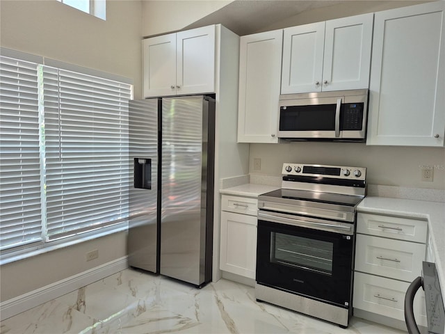 13546 Summerton Dr, Orlando, FL 32824 - kitchen with appliances with stainless steel finishes, light marble finish flooring, light countertops, and white cabinets