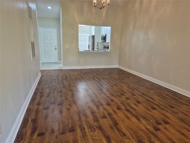 13546 Summerton Dr, Orlando, FL 32824 - unfurnished living room with dark wood finished floors and a chandelier