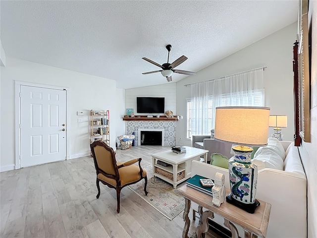 260 Killarney Bay Ct Unit 6-6, Winter Park, FL 32789 - living area featuring vaulted ceiling, a ceiling fan, light wood-style flooring, a textured ceiling, and a tile fireplace