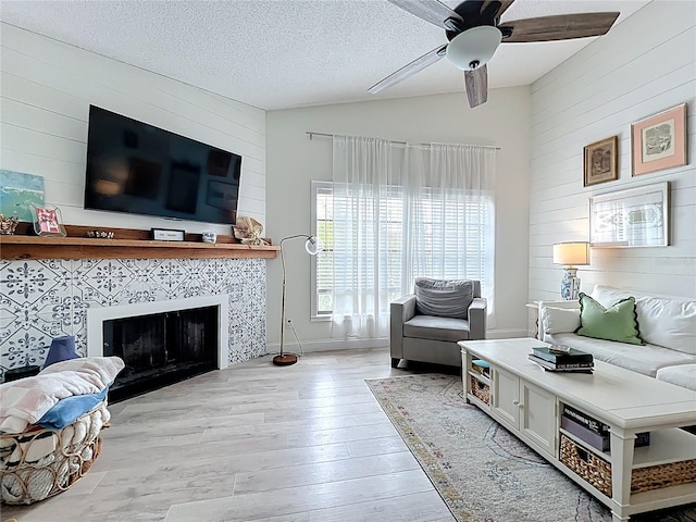 260 Killarney Bay Ct Unit 6-6, Winter Park, FL 32789 - living area with wood walls, vaulted ceiling, light wood-style floors, a tile fireplace, and a ceiling fan