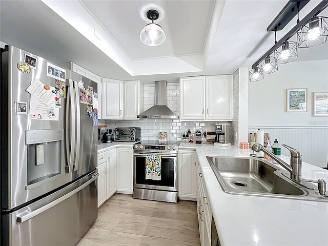 260 Killarney Bay Ct Unit 6-6, Winter Park, FL 32789 - kitchen featuring stainless steel appliances, wall chimney exhaust hood, light wood-style floors, light countertops, and white cabinetry