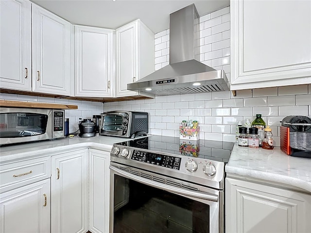 260 Killarney Bay Ct Unit 6-6, Winter Park, FL 32789 - kitchen with stainless steel appliances, wall chimney range hood, white cabinetry, tasteful backsplash, and light stone countertops