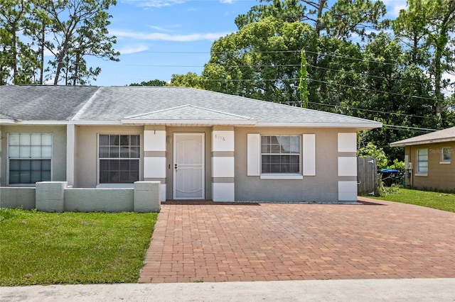 8116 Parrot Dr, Orlando, FL 32825 - view of front of property with a shingled roof, a front yard, and stucco siding
