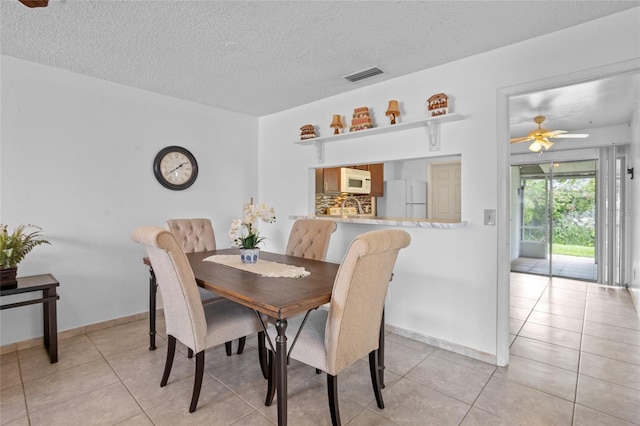 8116 Parrot Dr, Orlando, FL 32825 - dining space featuring a textured ceiling, light tile patterned flooring, and ceiling fan