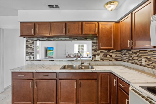 8116 Parrot Dr, Orlando, FL 32825 - kitchen featuring decorative backsplash, light stone counters, light tile patterned flooring, and white range