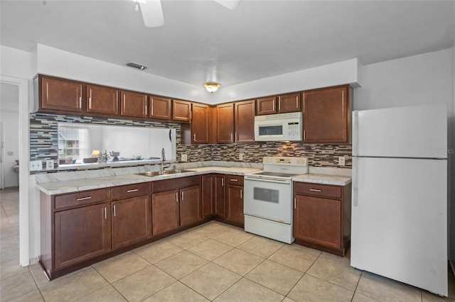 8116 Parrot Dr, Orlando, FL 32825 - kitchen with white appliances, backsplash, and light tile patterned floors