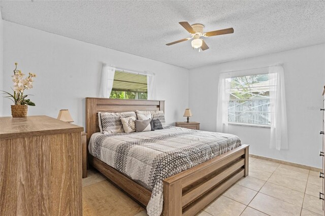 8116 Parrot Dr, Orlando, FL 32825 - bedroom featuring a textured ceiling, light tile patterned floors, and a ceiling fan