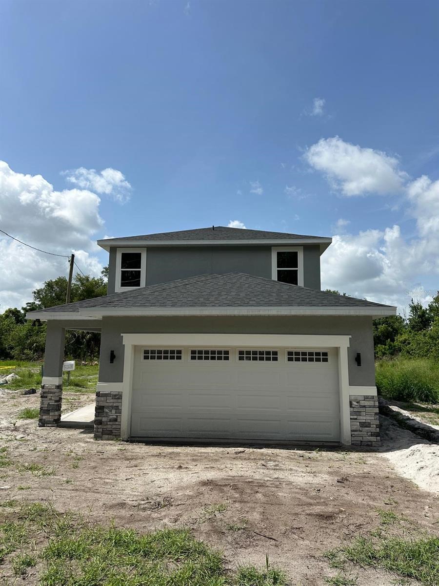 1132 Morse St, Altamonte Springs, FL 32701 - view of front of house featuring stucco siding, a garage, and stone siding